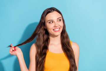 Photo portrait girl smiling touching long hair looking copyspace isolated pastel blue color background