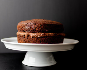 hand made naked chocolate cake on white stand 