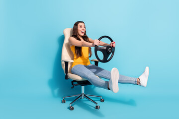 Full length body size photo girl keeping steering wheel sitting in office chair isolated pastel...