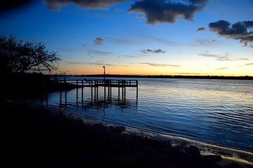 Naklejka na ściany i meble Fishing pier at sunset on the river at Florida, USA.
