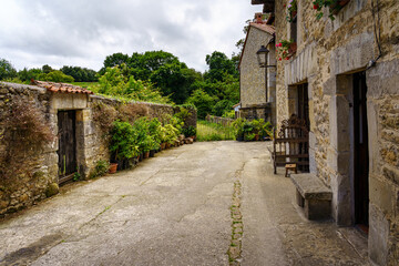 Corner of an old town with stone houses and walls with flowers. Santillana del Mar.