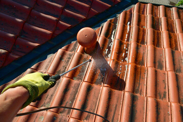 Behandlung eines Ziegeldachs mit Drucksprüher und Algizid gegen Algen-, Flechten- und Moos-Bewuchs