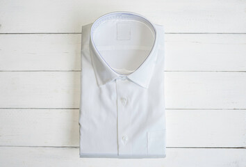 White shirt folding in the package on wooden background.