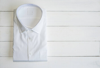 White shirt folding in the package on wooden background.