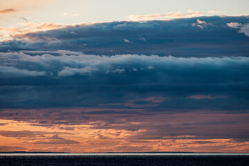 Sunset over a an overcast mountain range and ocean
