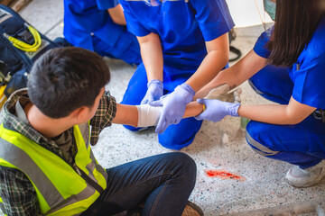 Physical injury at work of construction worker. Emergency medical teams are first aiding a...