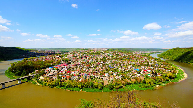 Wide angle landscape view of Zalishchyky town and canyon with Dnister River. Spring sunny landscape. Ternopil region, Ukraine. Nature and travel concept