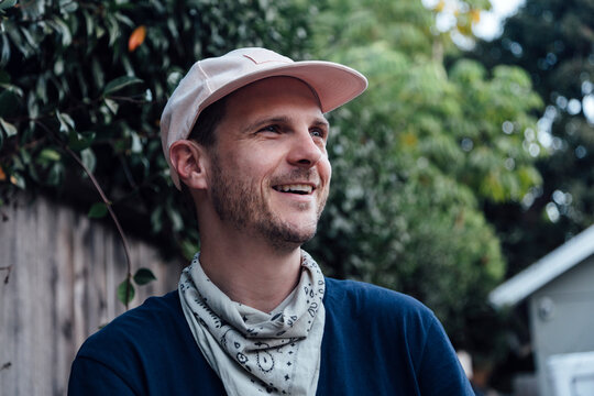 Smiling man with bandana looking away in backyard