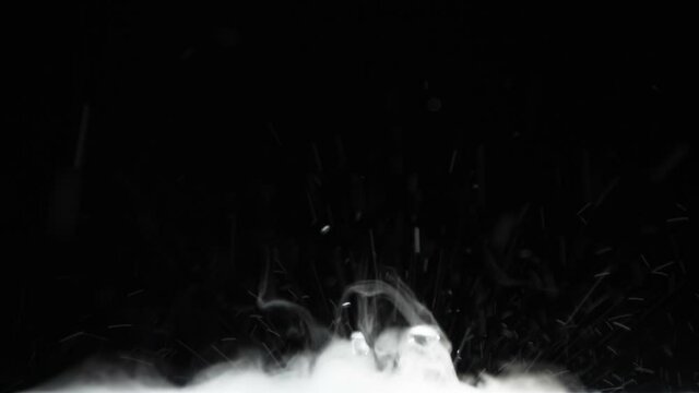 Intensive Chemical Reaction. Slow Motion. A mixture of liquid and white smoke intensively boils at the bottom of the screen on a black background