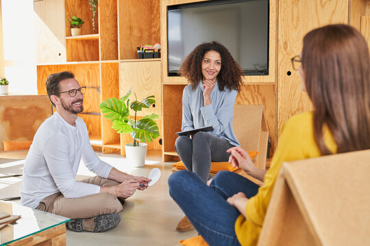 Entrepreneurs listening to female colleague in creative office
