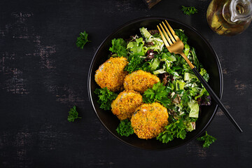 Homemade fish croquettes from white fish in cornflakes breading. Fritters from minced cod. Delicious and nutritious lunch or dinner. Top view, overhead