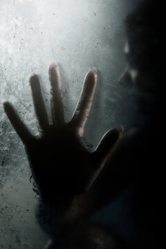 Silhouette hand on frosted glass