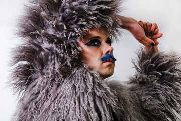 Man in fur coat looking away against white background