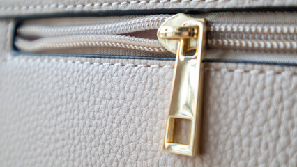 Natural or artificial leather texture. Fragment of a beige or powdery bag with a zipper and...