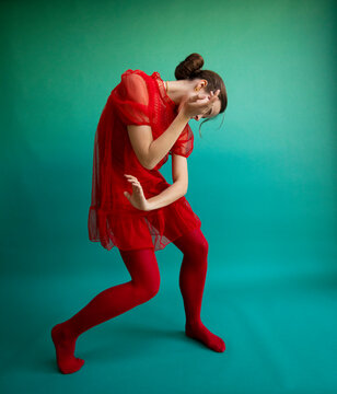 Female ballet dancer dancing against turquoise background