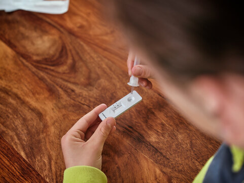 Boy examining corona virus test at home