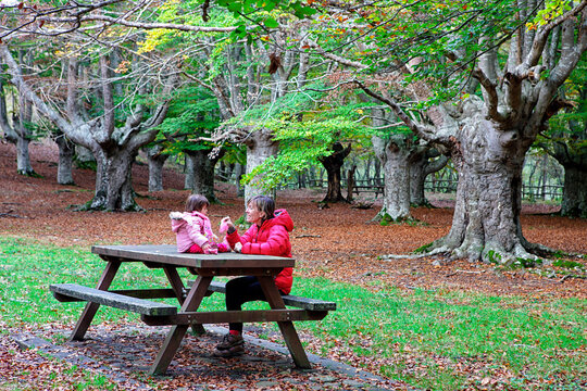 Mother sitting with daughter on bench in Gorbea Natural Park