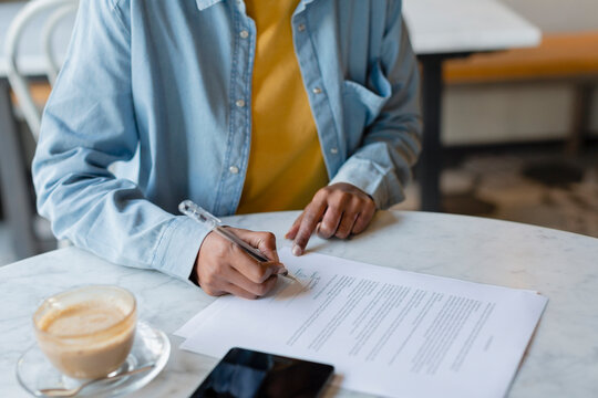 Female professional signing contract in cafe