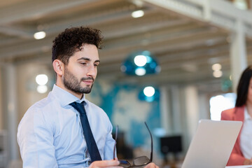 Male professional working on laptop in coworking office