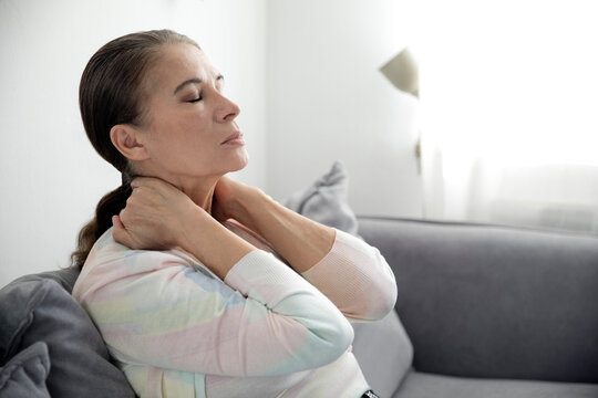 Tired woman siting with eyes closed on sofa
