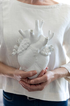 Woman holding white heart model