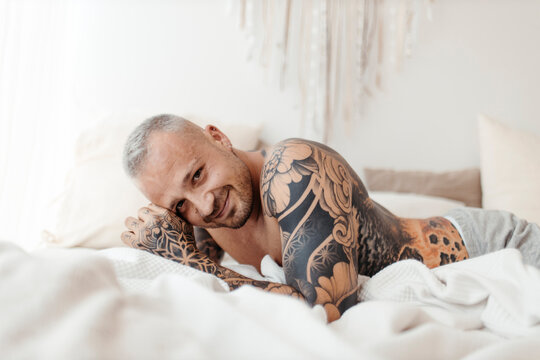 Happy man lying on bed at home