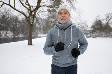 Senior man wearing warm clothing running at park