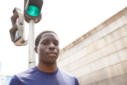 African man standing in front of road signal during sunny day
