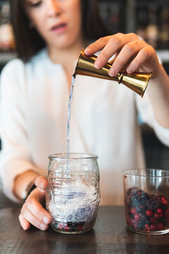 Female bartender preparing cocktail at bar counter