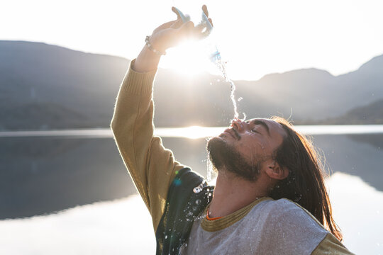 Man pouring water over face during sunny day