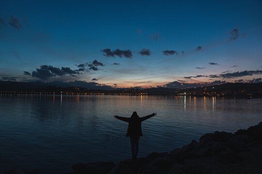 Spain, Cantabria, San Vicente de la Barquera, Young tourist enjoying sea coast at dusk