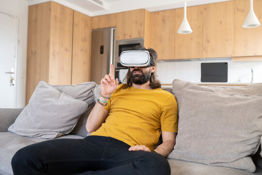 Mature man gesturing while wearing virtual reality headset at home