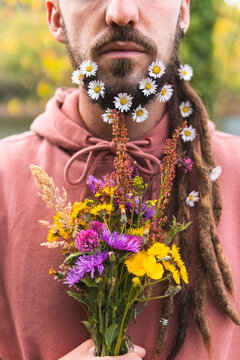 Young man holding bunch of flowers