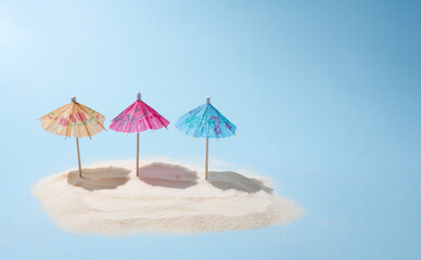 Three colorful umbrellas on the island of sand in the sunshine, a summer beach vacation and travel concept.