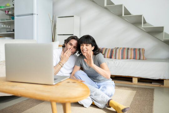 Mature couple gesturing during video call on laptop at home