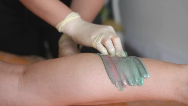Applying the master sugar paste to depilation on the leg