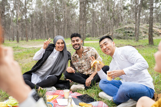 Cheerful male and female friends posing during party in forest