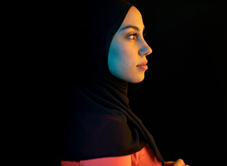 Young Arab woman with headscarf against black background