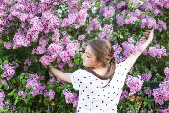 Young woman embracing a lilac shrub