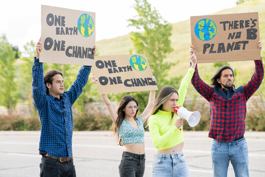 Angry female activist with megaphone announcing while protesting on climate change