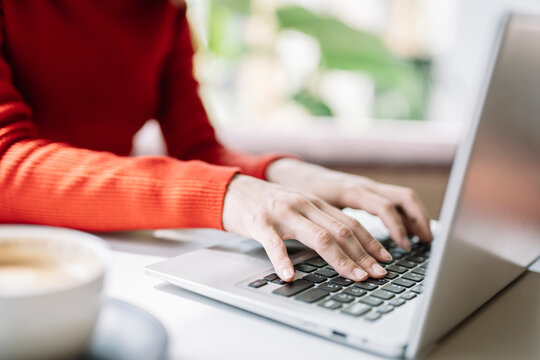 Young woman using laptop at table in cafe