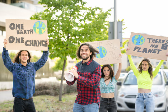 Smiling male activist protesting against climate change on city street