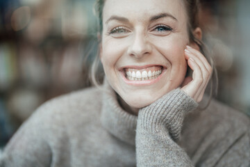 Beautiful woman with toothy smile at cafe
