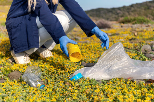 Woman collecting plastic garbage on sunny day