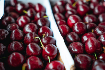 Sweet Cherries on a white wooden box. Fresh juicy red cherry berry rotate. Tasty natural desserts for healthy eating. Raw dessert food with sweet taste