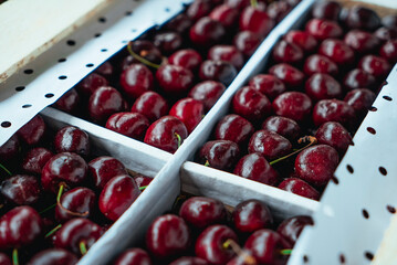 Sweet Cherries on a white wooden box. Fresh juicy red cherry berry rotate. Tasty natural desserts for healthy eating. Raw dessert food with sweet taste