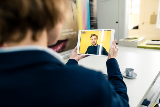 Businesswoman working with colleague through video call on digital tablet in industry