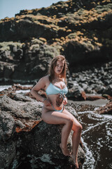 Chica veraniega surfera en playa cala de arena negra en las islas canarias paraiso