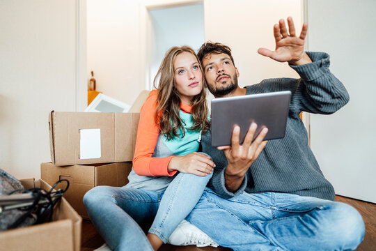 Young couple sitting with digital tablet planning at home
