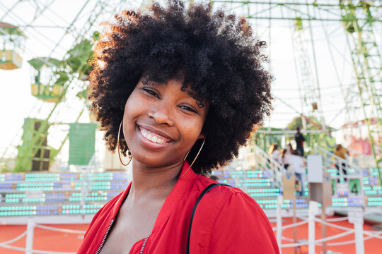 Young woman smiling in amusement park - Powered by Adobe